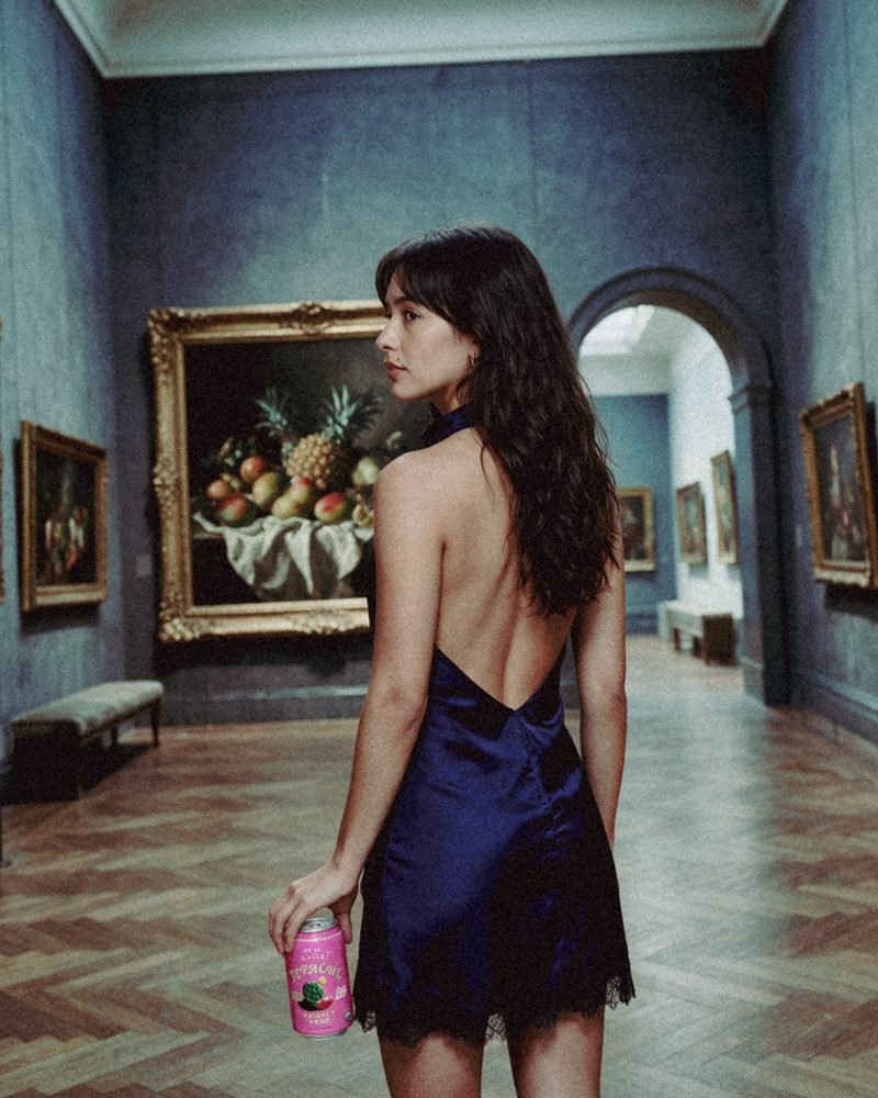 Mulher de costas num museu com uma lata na mão